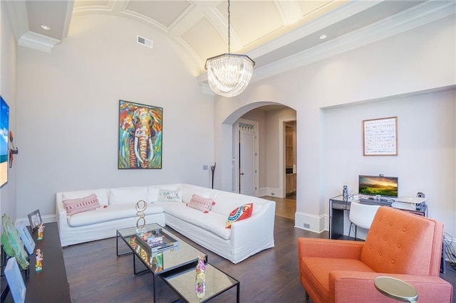 living room featuring a chandelier, dark wood-type flooring, and ornamental molding