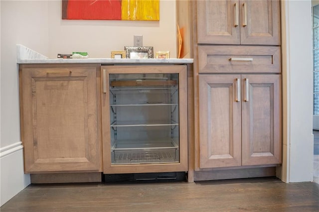 bar with dark wood-type flooring and beverage cooler