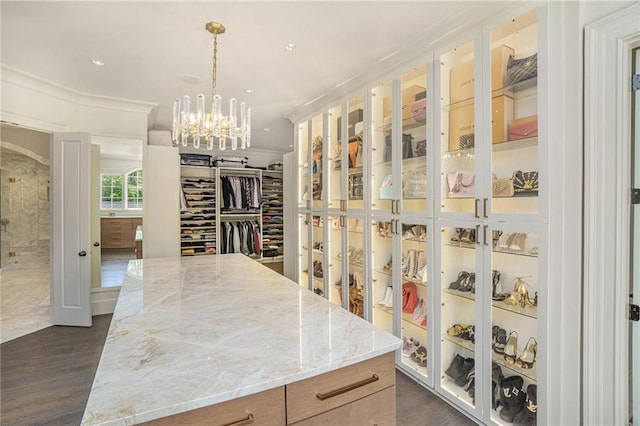 spacious closet featuring an inviting chandelier and dark wood-type flooring