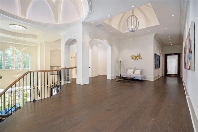 corridor featuring dark hardwood / wood-style flooring, a notable chandelier, and a tray ceiling