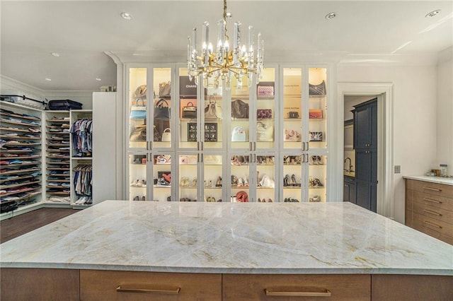 interior space with an inviting chandelier, crown molding, and dark wood-type flooring