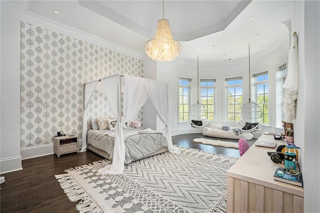 bedroom with a notable chandelier, hardwood / wood-style floors, and a tray ceiling