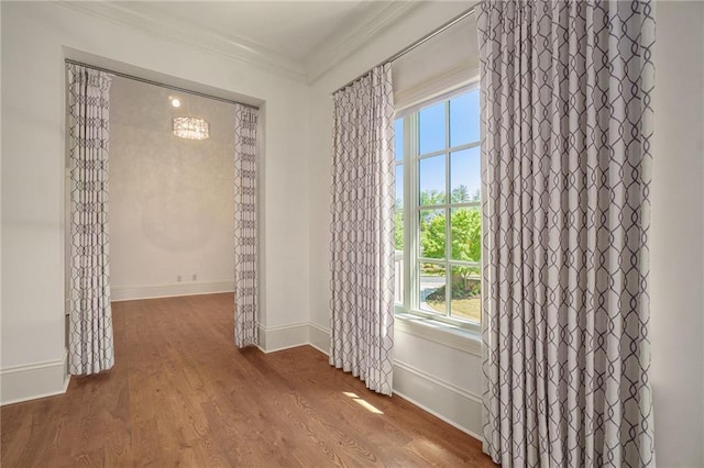 empty room with ornamental molding and dark hardwood / wood-style floors