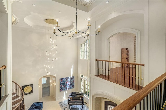 interior space featuring a chandelier, light tile floors, and a high ceiling