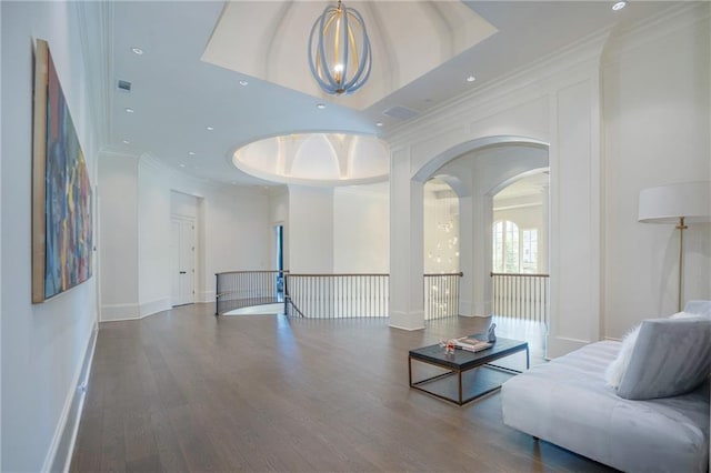 living room with dark wood-type flooring and a tray ceiling