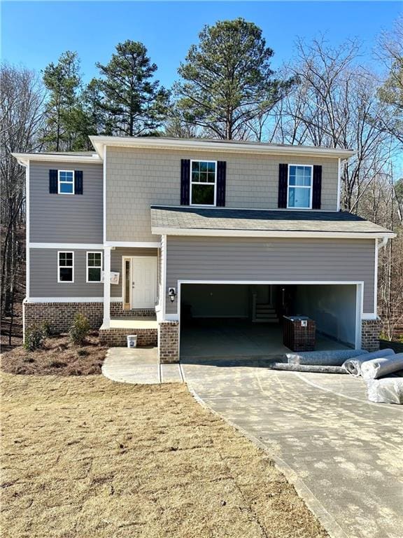 view of front facade with an attached garage, cooling unit, concrete driveway, and brick siding