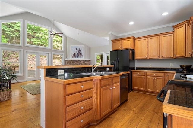 kitchen with sink, black appliances, lofted ceiling, and light hardwood / wood-style flooring