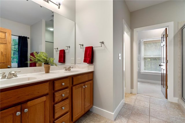 bathroom with a shower with shower door, vanity, and tile patterned floors