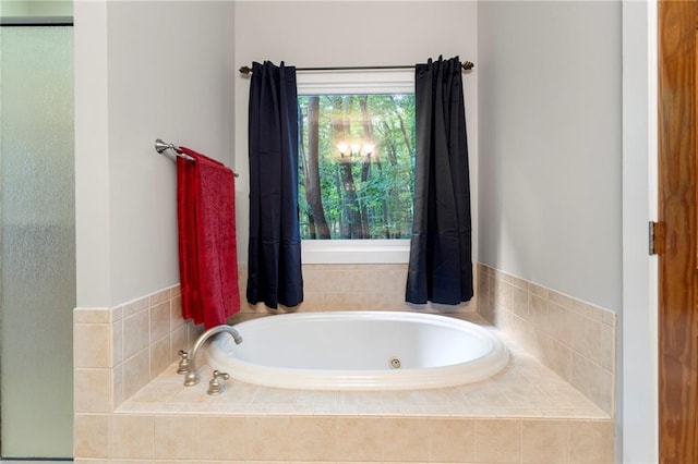 bathroom with tiled bath and a healthy amount of sunlight