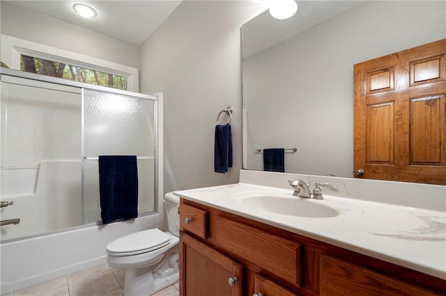 full bathroom featuring shower / bath combination with glass door, vanity, toilet, and tile patterned flooring