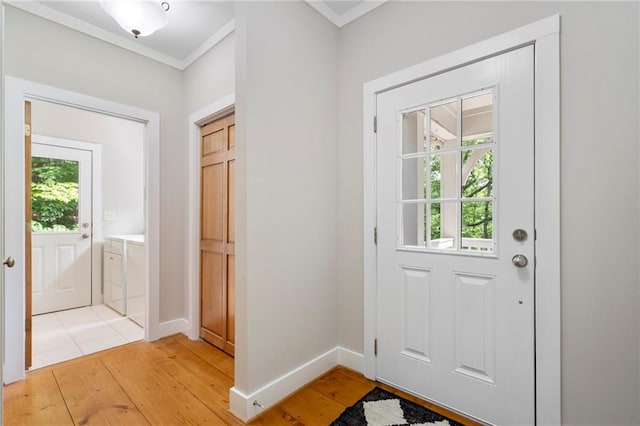 doorway to outside with crown molding and light hardwood / wood-style flooring