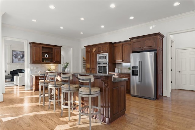 kitchen with a kitchen island, decorative backsplash, a kitchen bar, and appliances with stainless steel finishes