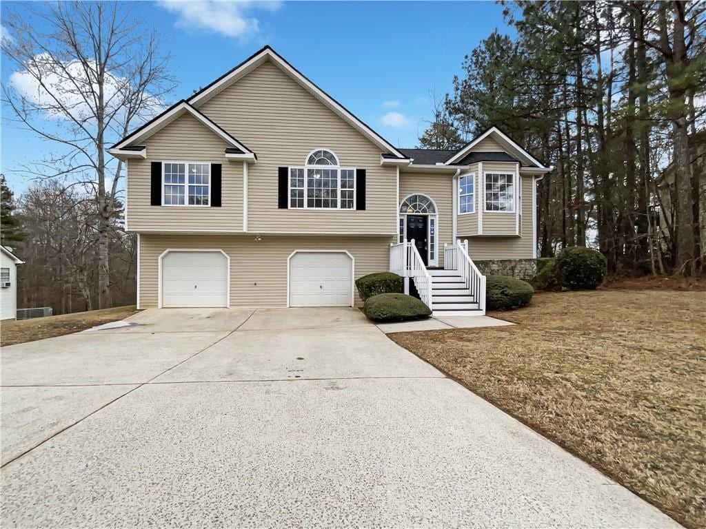 split foyer home featuring a garage and a front yard