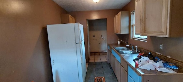 kitchen featuring light tile patterned flooring, white fridge, sink, and light brown cabinetry