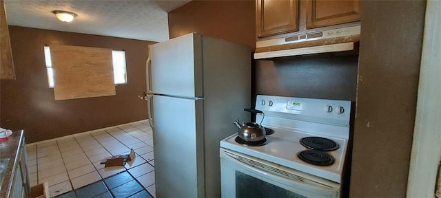 kitchen featuring light tile patterned floors and white appliances