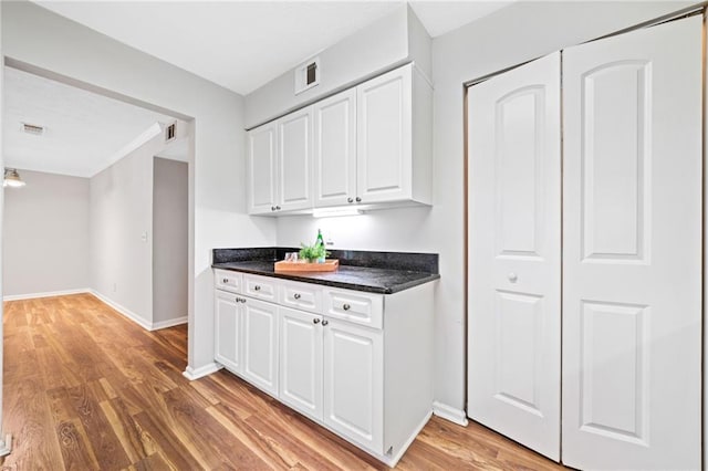 717 Beaufort Cir, Duluth, GA 30096 - kitchen featuring dark countertops, white cabinetry, light wood-type flooring, and baseboards