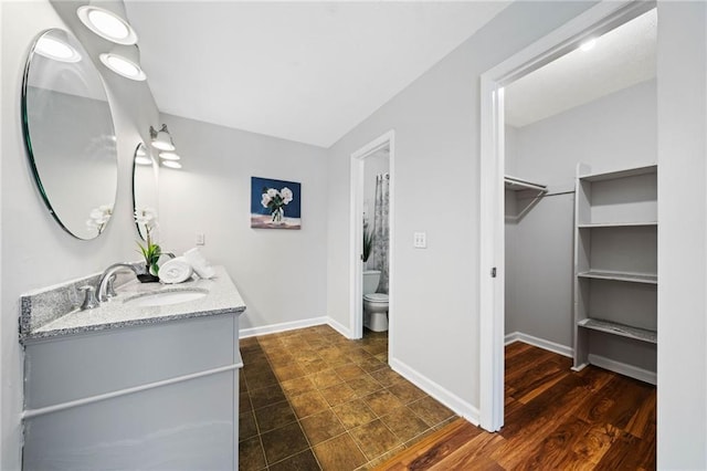 717 Beaufort Cir, Duluth, GA 30096 - bathroom with toilet, a spacious closet, vanity, and baseboards