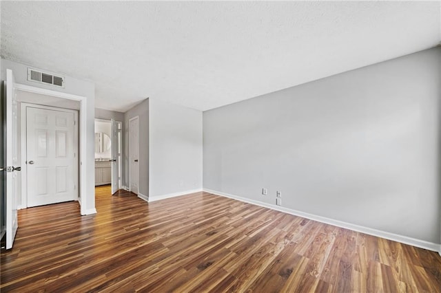 717 Beaufort Cir, Duluth, GA 30096 - unfurnished bedroom with baseboards, dark wood-style floors, and a textured ceiling