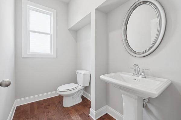 bathroom with toilet and hardwood / wood-style floors