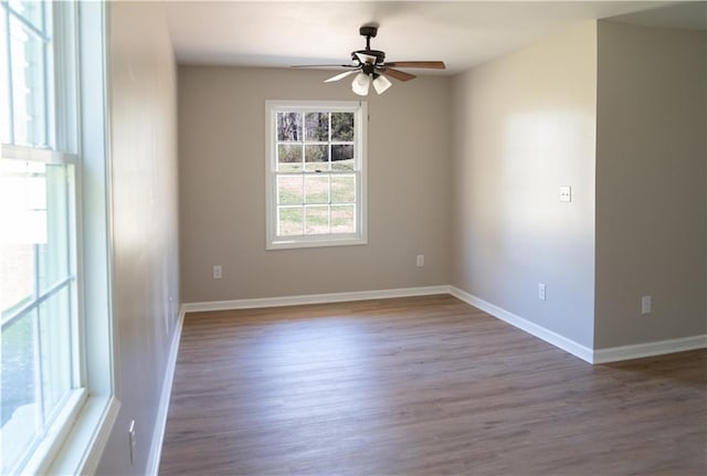 unfurnished room with wood finished floors, baseboards, and ceiling fan