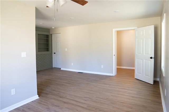 spare room with wood finished floors, baseboards, and ceiling fan