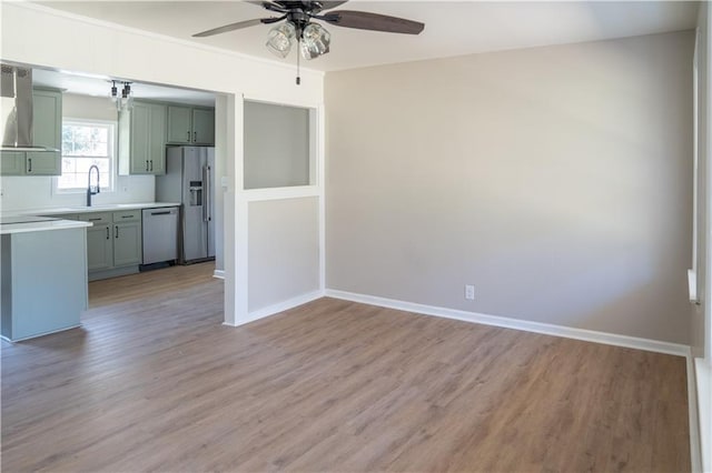 interior space featuring baseboards, light wood-style floors, and a ceiling fan