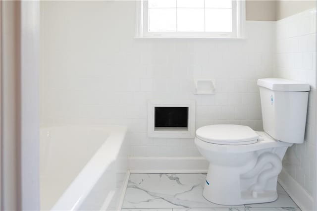 full bathroom featuring tile walls, toilet, marble finish floor, and a bathing tub