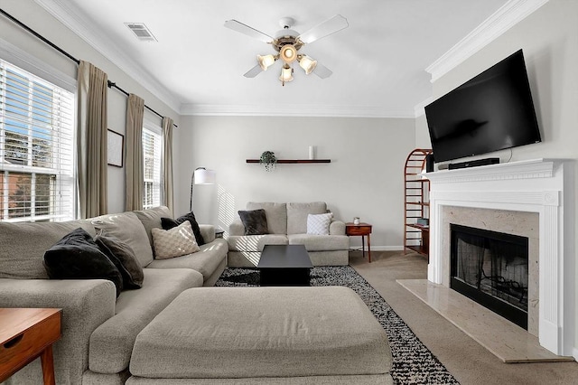 carpeted living room featuring a fireplace, ceiling fan, and ornamental molding