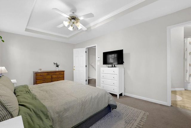 bedroom featuring a tray ceiling, ceiling fan, carpet, and ornamental molding