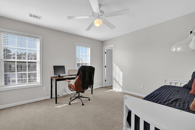 bedroom with light carpet, multiple windows, and ceiling fan