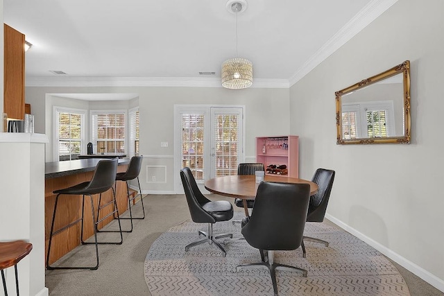 dining area featuring light colored carpet, crown molding, and french doors