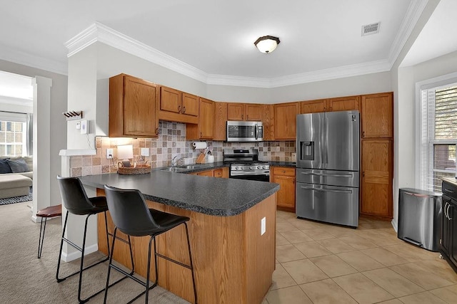 kitchen featuring kitchen peninsula, appliances with stainless steel finishes, and crown molding