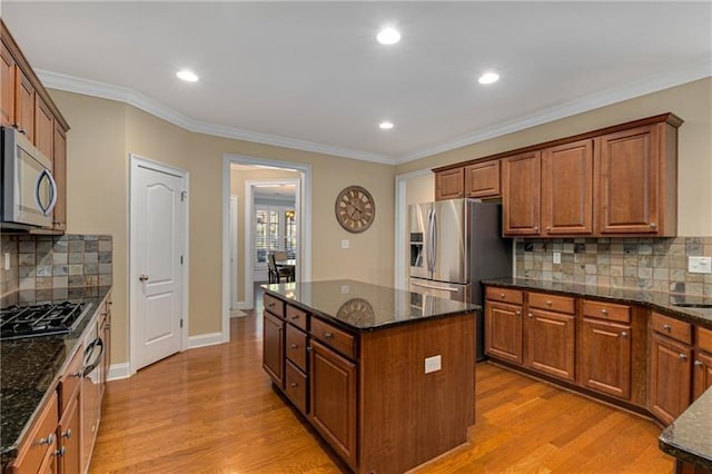 1725 Lynwood Pl, Alpharetta, GA 30004 - kitchen featuring stainless steel appliances, a center island, light wood-style floors, dark stone counters, and crown molding