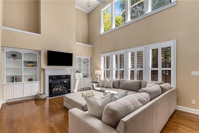 1725 Lynwood Pl, Alpharetta, GA 30004 - living room with a high ceiling, wood finished floors, baseboards, a glass covered fireplace, and ornamental molding