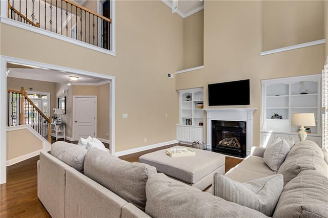 1725 Lynwood Pl, Alpharetta, GA 30004 - living area featuring baseboards, stairway, dark wood-type flooring, a glass covered fireplace, and a high ceiling