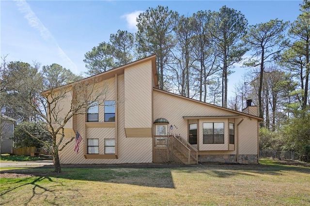 view of front of home with a front yard, fence, and a chimney