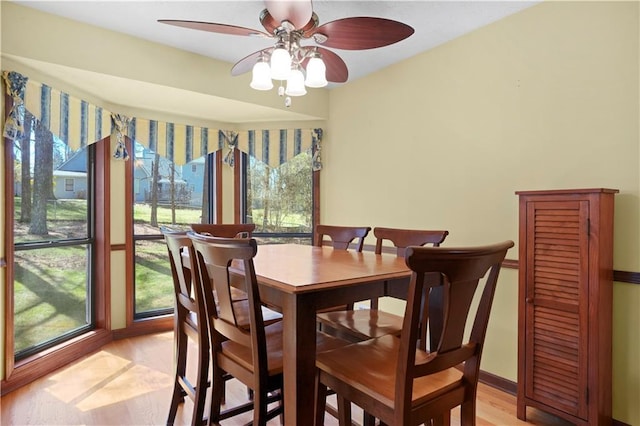 dining room with ceiling fan, baseboards, plenty of natural light, and light wood-style flooring