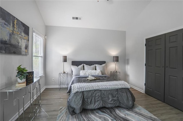 bedroom with lofted ceiling, visible vents, and wood finished floors