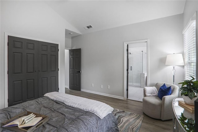 bedroom with vaulted ceiling, a closet, wood finished floors, baseboards, and visible vents