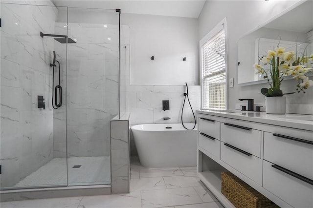 bathroom with marble finish floor, a marble finish shower, a freestanding tub, and vanity