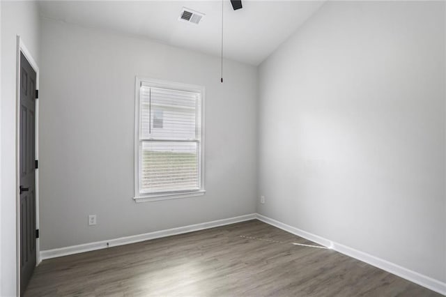 spare room with baseboards, visible vents, wood finished floors, and ceiling fan
