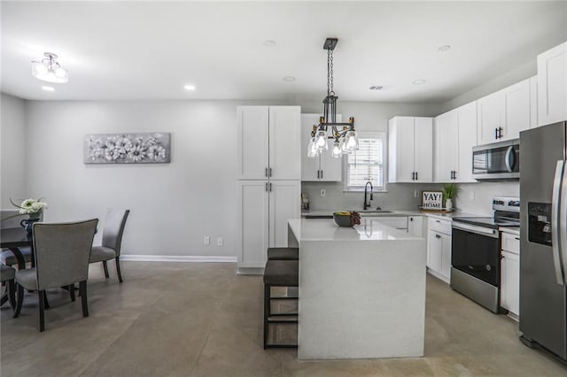 kitchen with white cabinetry, light countertops, a center island, backsplash, and appliances with stainless steel finishes