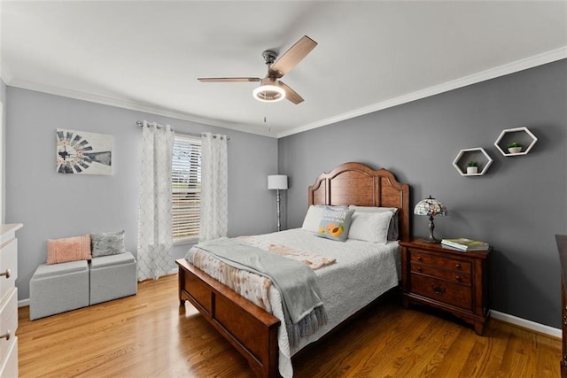 bedroom with ceiling fan, ornamental molding, wood finished floors, and baseboards