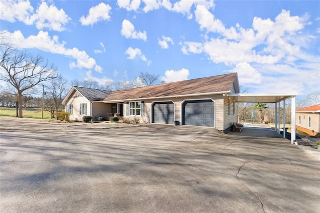 view of front facade featuring driveway, a carport, and an attached garage