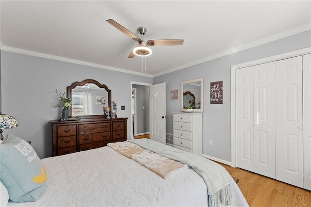 bedroom featuring a closet, ornamental molding, ceiling fan, wood finished floors, and baseboards