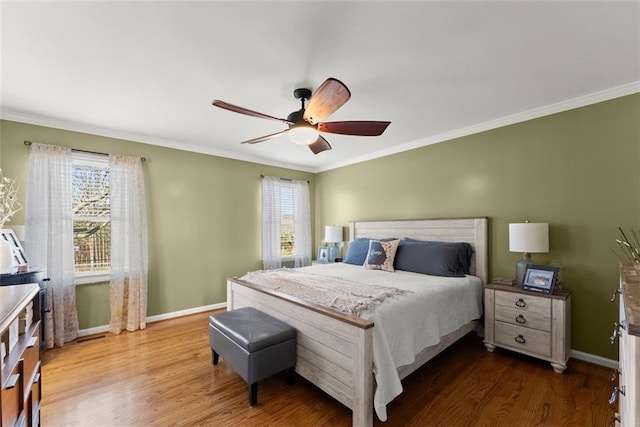 bedroom featuring crown molding, baseboards, ceiling fan, and wood finished floors