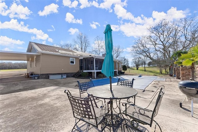 view of patio with outdoor dining space, a sunroom, and grilling area