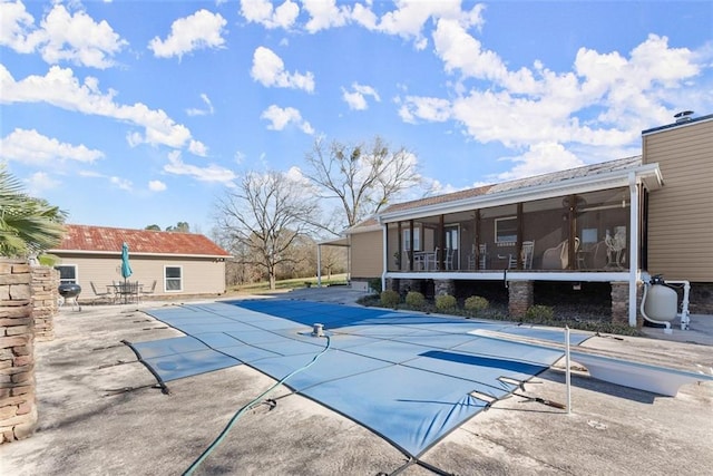 view of pool with a patio area, a sunroom, and a covered pool