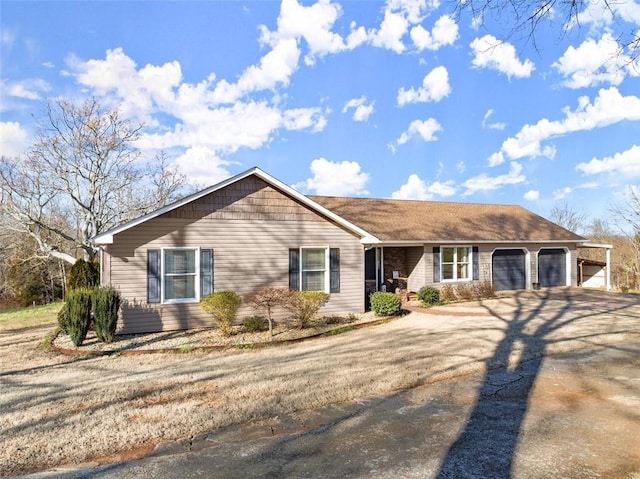 single story home with a garage and aphalt driveway