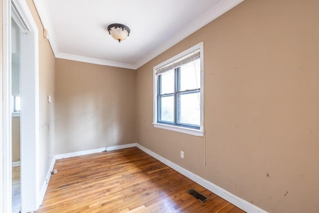 spare room with ornamental molding and light hardwood / wood-style floors